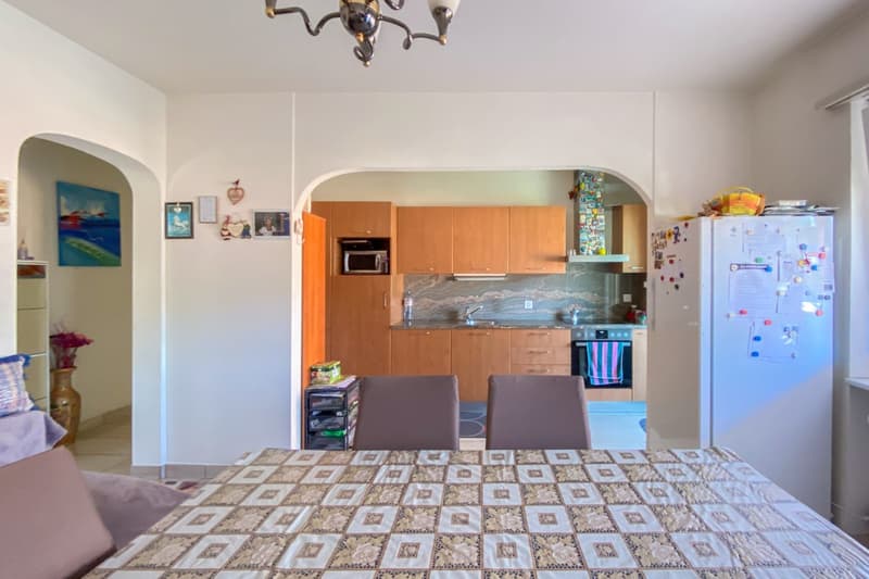 Dining area with table, chairs, counter, kitchen with cabinets, microwave, refrigerator, sink, countertop