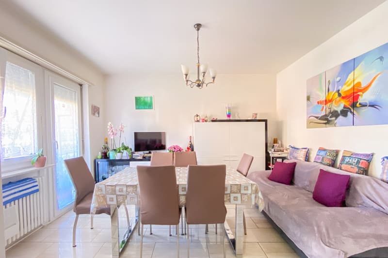 Dining room, table and chairs, couch with pillows, large windows, chandelier