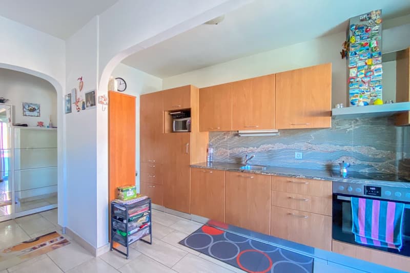 kitchen with wooden cabinets, granite countertop, stainless steel appliances, microwave, sink with faucet