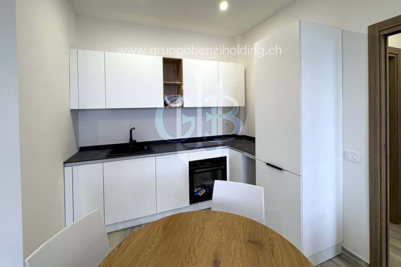 modern kitchen, white cabinets, black countertops, wooden table, white chairs