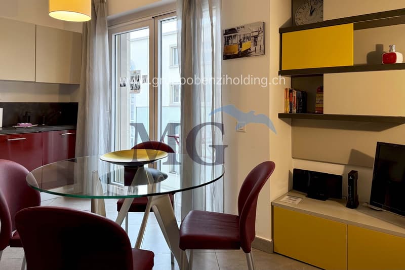 kitchen with dining area, round glass table, red chairs, modern design, glass door, yellow shelves, flat screen TV, open space