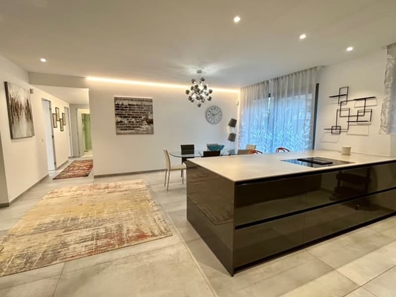 open-plan layout with dining table, center island, chandelier, dining chairs, artwork on the wall, and a rug