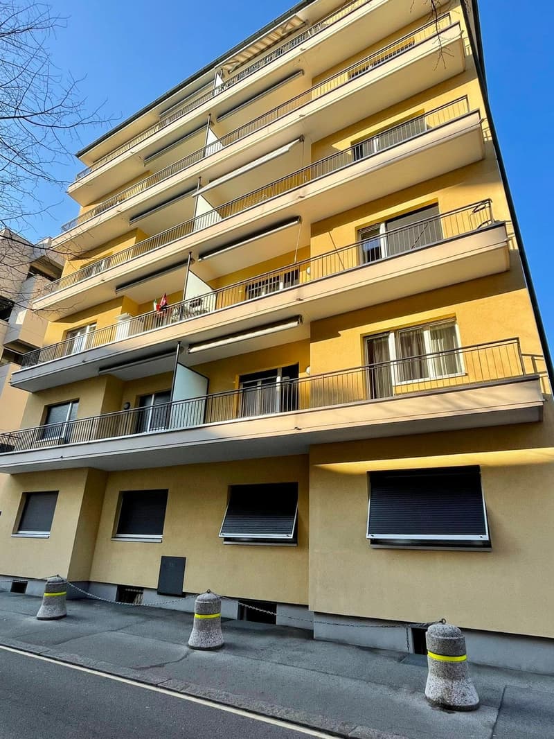 6 story yellow building, multiple balconies, chain-link fencing, metal chain barrier