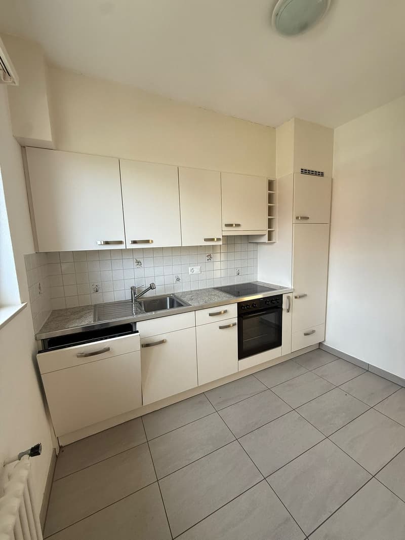 White kitchen, sink with faucet, oven, tiled floor, cabinets