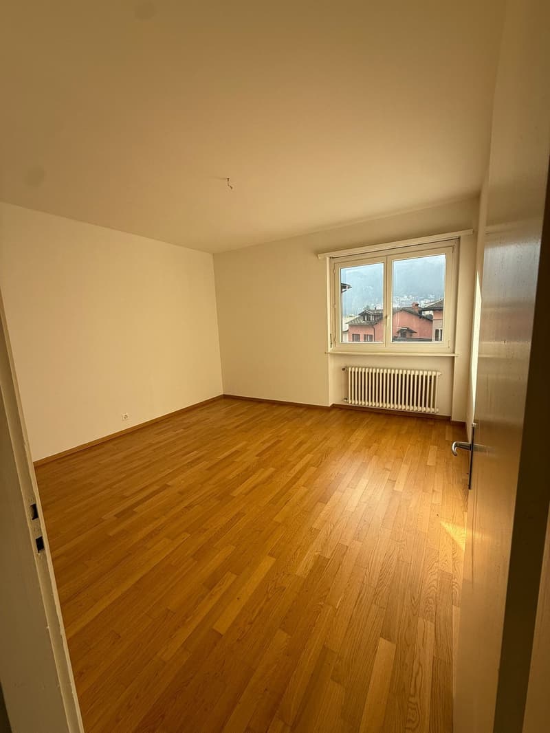 empty room, wooden floor, white walls, large window, radiator