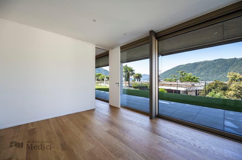 wooden floor, large windows with glass doors, balcony, view of mountains and lake