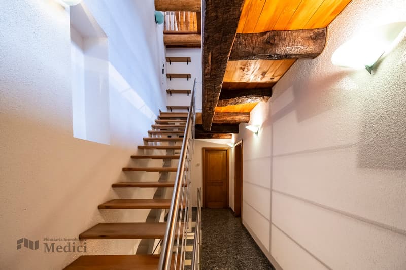 Wooden staircase, tiled floor, white walls, wooden ceiling, lamp