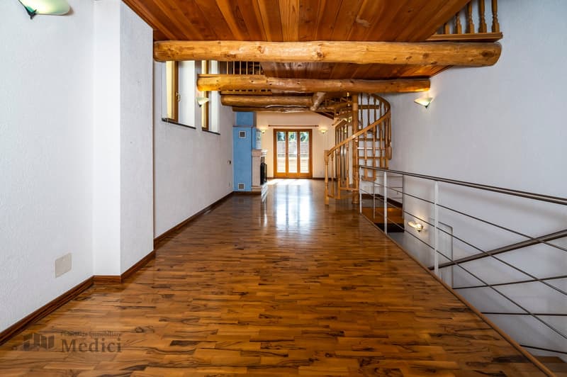 Wide wooden hallway, white walls, wooden ceiling, hardwood floor, spiral staircase, wall-mounted lights
