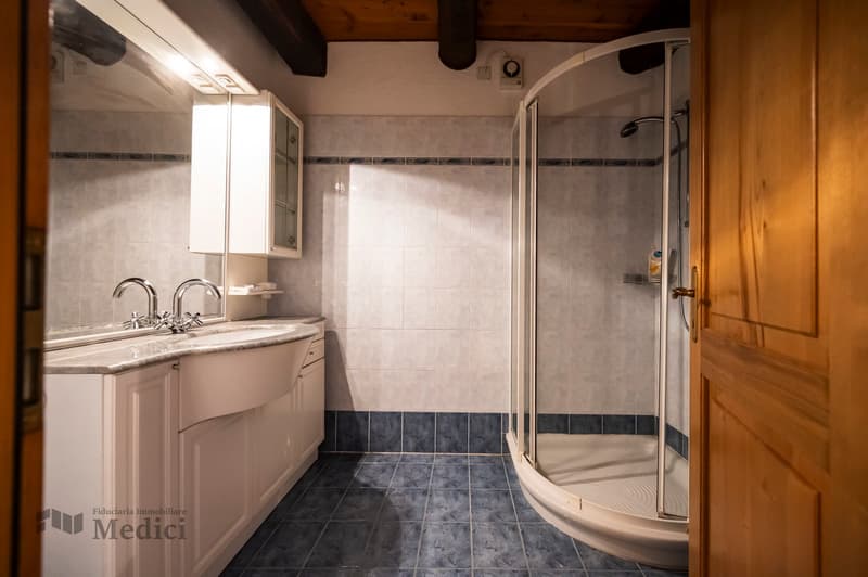 Bathroom with sink, mirror, and shower.