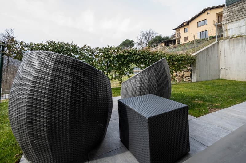 outdoor patio with wicker chairs, table, and view of landscape