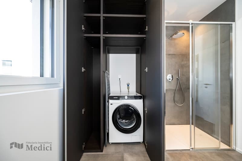 Small laundry room with washer, dryer and shower