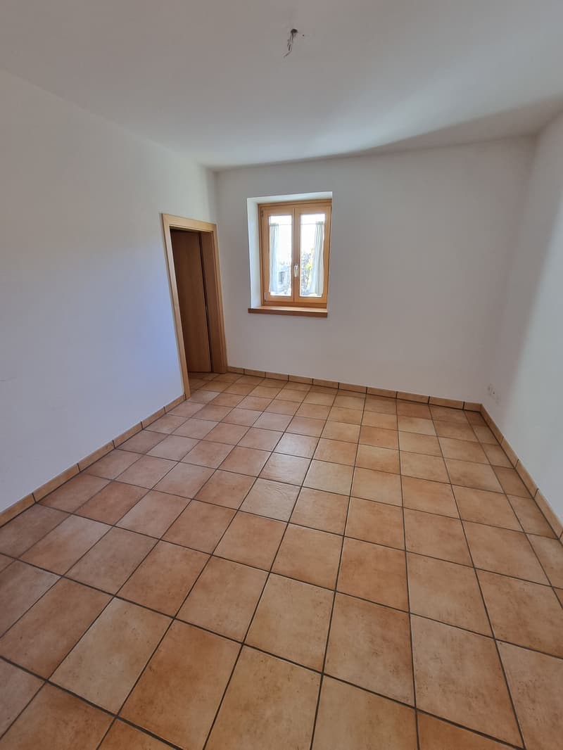 empty room, brown tiles, white walls, wooden window frames, power outlet, open door