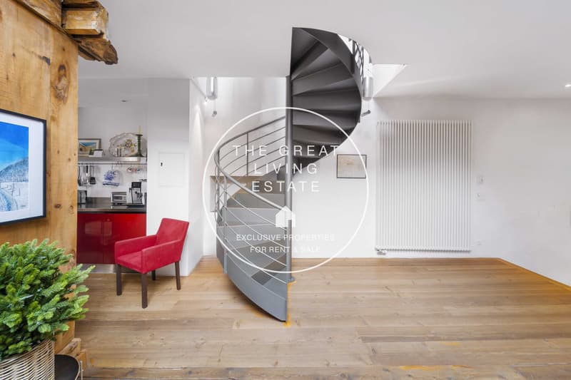 spiral staircase, hardwood flooring, red chair, wooden wall, radiator, framed picture, modern kitchen area