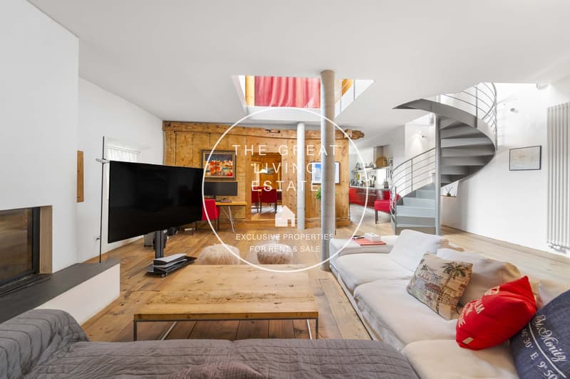 Living room with white walls, wooden floor, white sofa, wooden coffee table, flat screen TV, fireplace, spiral staircase