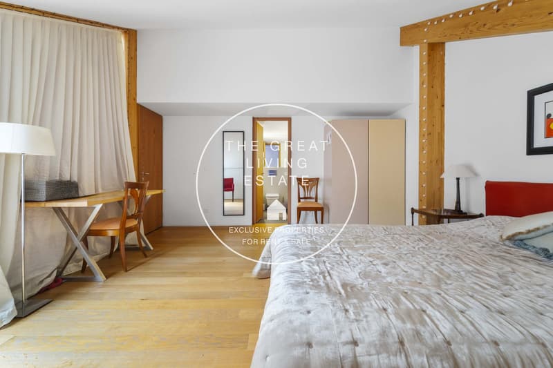 wooden floors, white walls, bed, wooden desk and chairs, lamps, picture frame, mirror