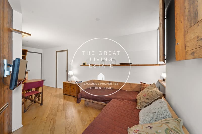 wooden floor, double bed, sofa bed, pillows, lamp, tv, wooden desk, red chair