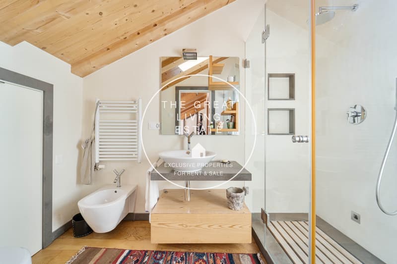 Modern bathroom with wooden ceiling, white walls, walk-in shower, standalone bathtub, vanity with sink, towel rack, and tiled floor.