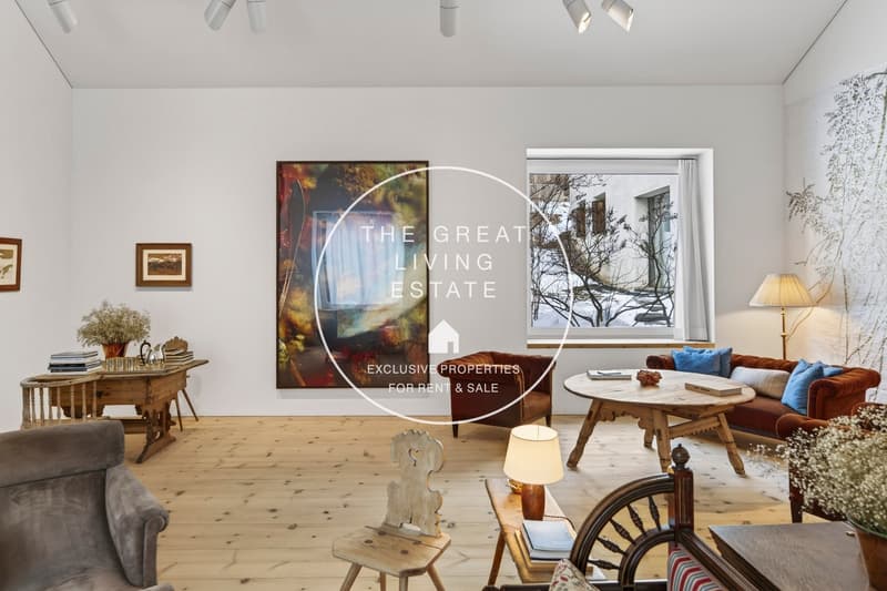 large living room, wooden floors, white walls, large window, artwork, couches, table, lamps