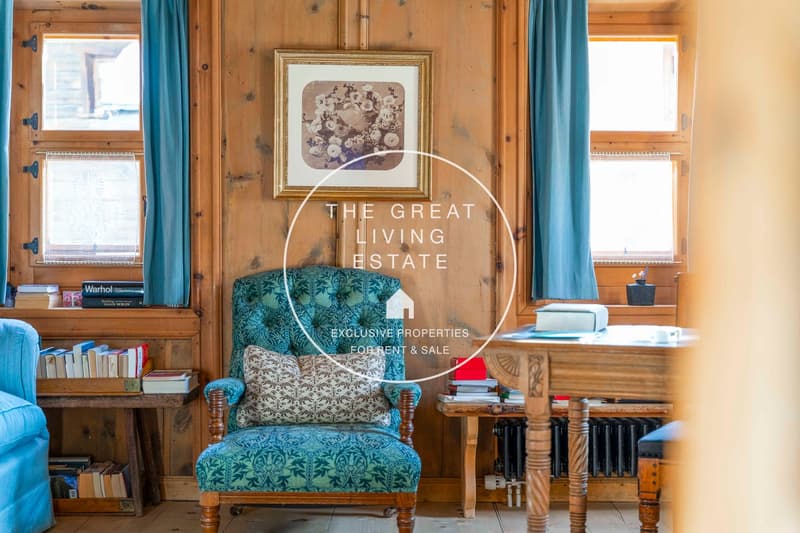 wooden wall, green chair, picture frame, books, wooden desk
