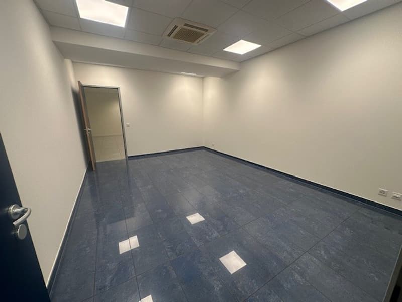 empty room, white walls, blue tile flooring, open door, power outlet