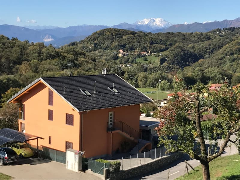 2 story house, orange exterior, black roof, solar panels, carport, mountain view