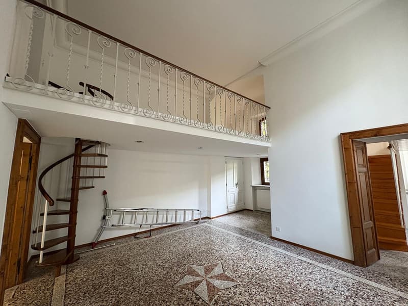 open room with staircase, balcony, tiled floor, ladder