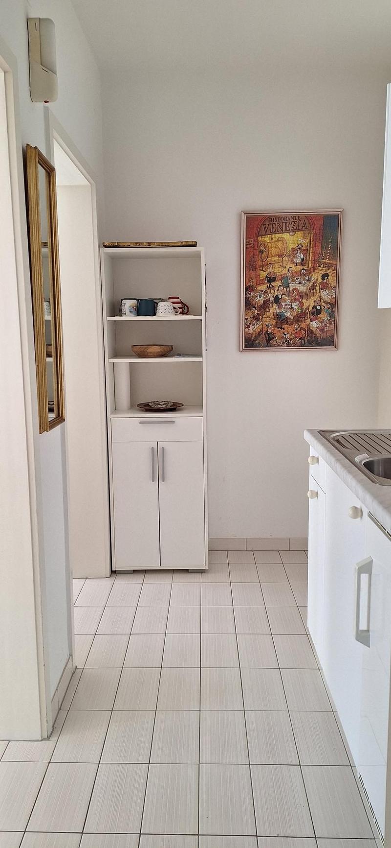 minimalist kitchen with white shelves and tile flooring, white walls and simple decor
