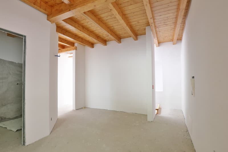 Open space, wooden ceiling, white walls, floor yet to be finished