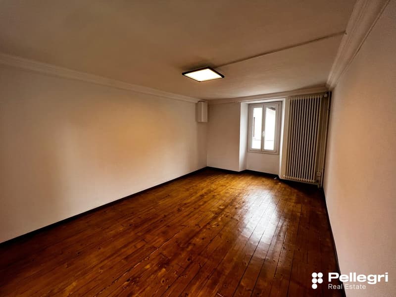 Spacious room with hardwood flooring, white walls, and a window. The room appears to be empty, ready for furnishing and decorating.