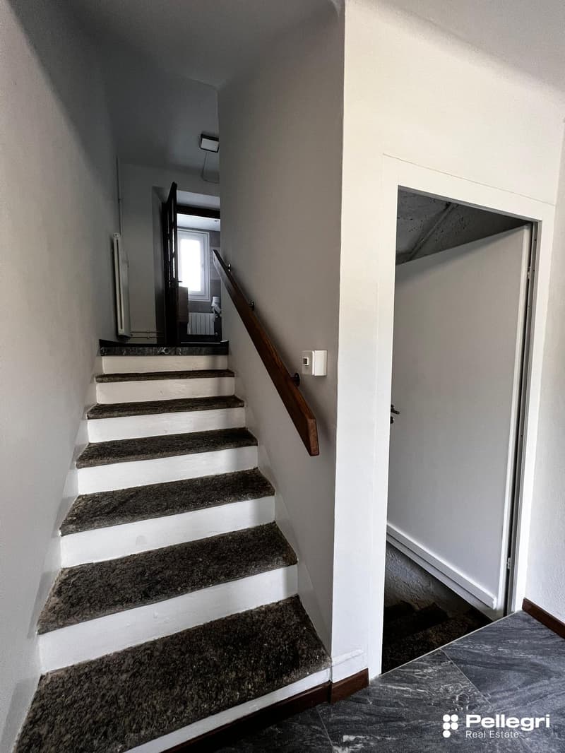 The image shows a staircase with granite steps leading up to a second floor. The walls are painted in a light color, and there is a wooden handrail along the stairs. The staircase appears to be located in a residential property.