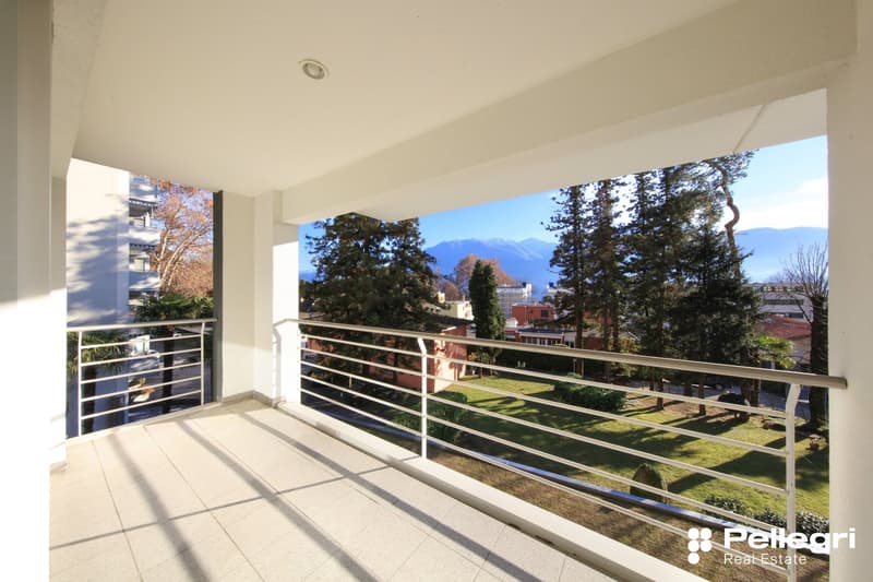 Modern balcony with tiled floor, stainless steel railings, and panoramic views of the surroundings.