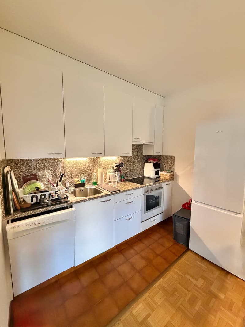 modern kitchen with white cabinets, granite countertop, stainless steel sink, dishwasher, refrigerator, oven, and a granite backsplash