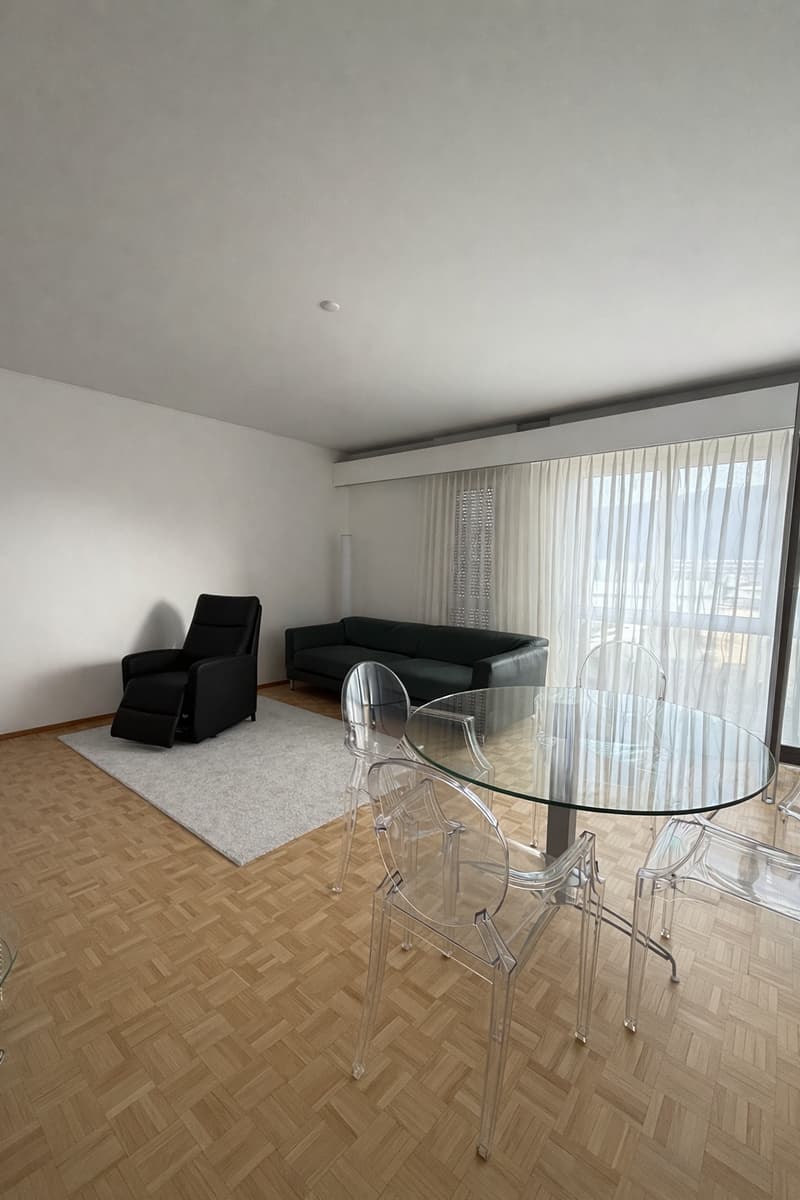 modern living room with a couch, a recliner, a glass table, and a white rug