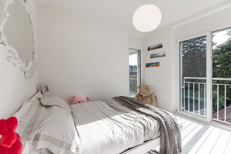 white walls, white bed, white bedding, white mirror, white ceiling lamp, white floor, balcony, teddy bears, picture frame