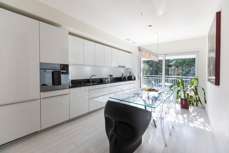 modern kitchen, white cabinets, glass table, balcony, plants, view of trees