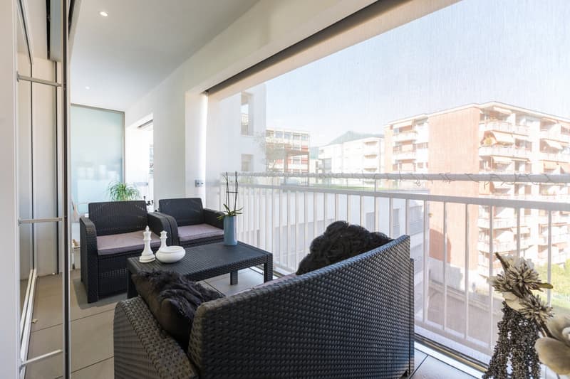 balcony, wicker furniture, table, plants, view of buildings