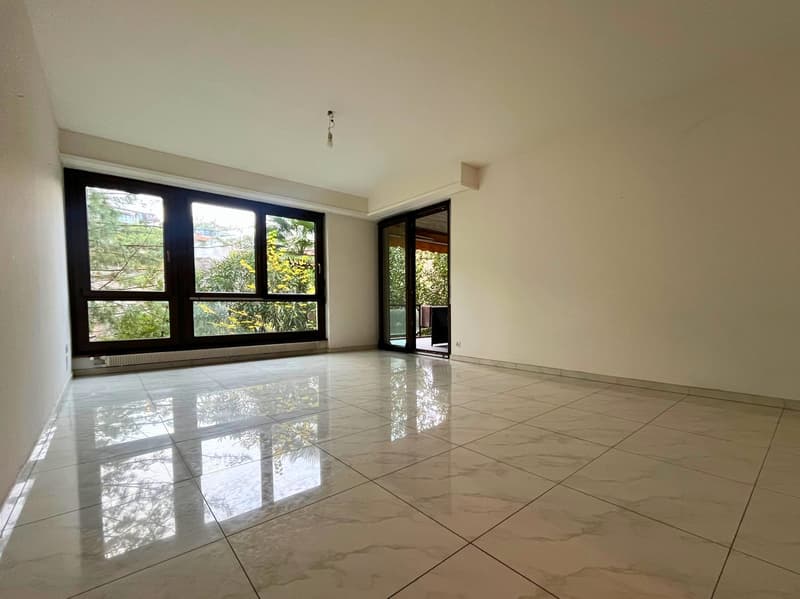 Spacious room, large windows, glass sliding doors to balcony, white tiles
