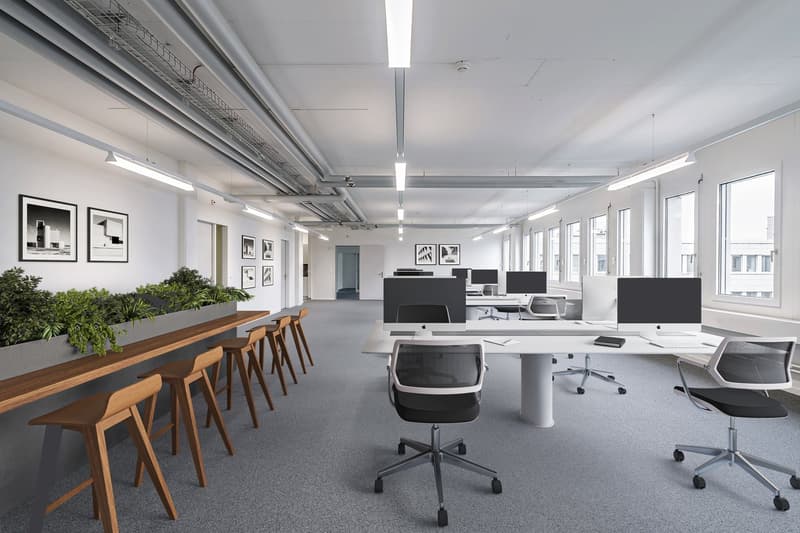 modern office space with desks, chairs, monitors, plants, and large windows