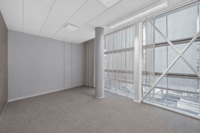 empty room with gray floor and walls, tall white windows, tall column, curtains