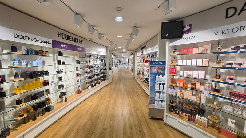 A store with wooden floor, glass shelves, and products on display