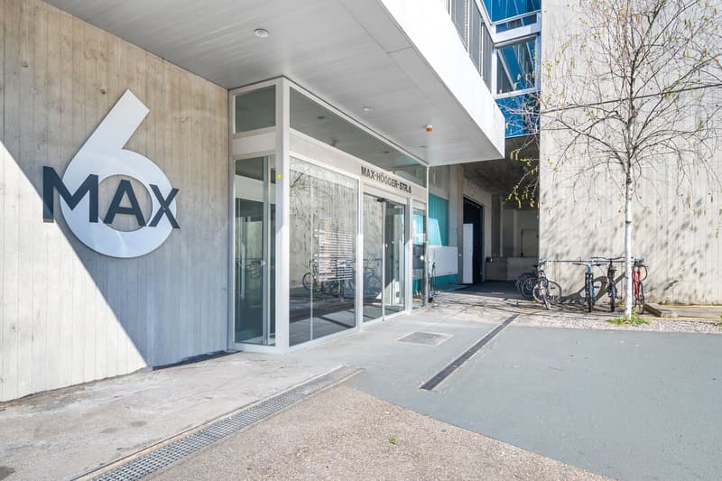 Concrete wall, glass entrance, bicycles parked outside