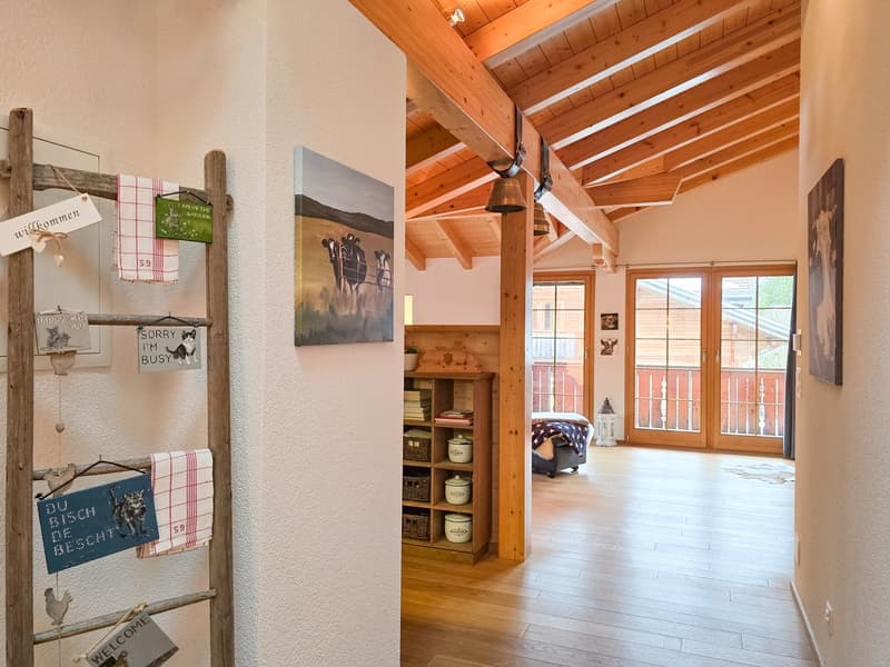wooden ceiling, wooden floor, wooden shelf, glass doors, wooden ladder with hanging items, paintings on the wall