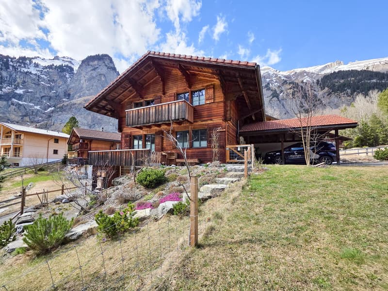 wooden chalet, balcony, garage, raised ground floor, car parked, mountain view