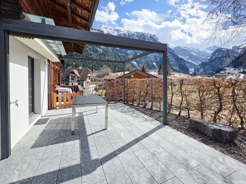 Terrace with table, metal roof, stone floor, view of mountains