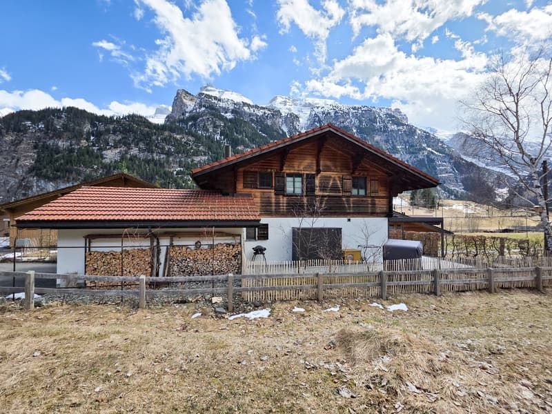 Wooden house, red roof, wooden fence, mountains in the background
