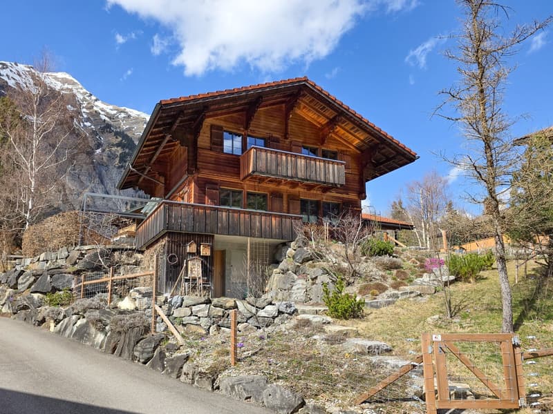 wooden chalet, red roof, wooden balcony, stone wall, mountain view