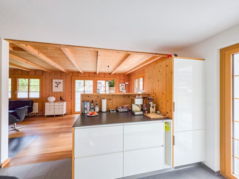 modern kitchen with wooden ceiling, white cabinets, granite countertop, coffee machine, fruits, wooden floor
