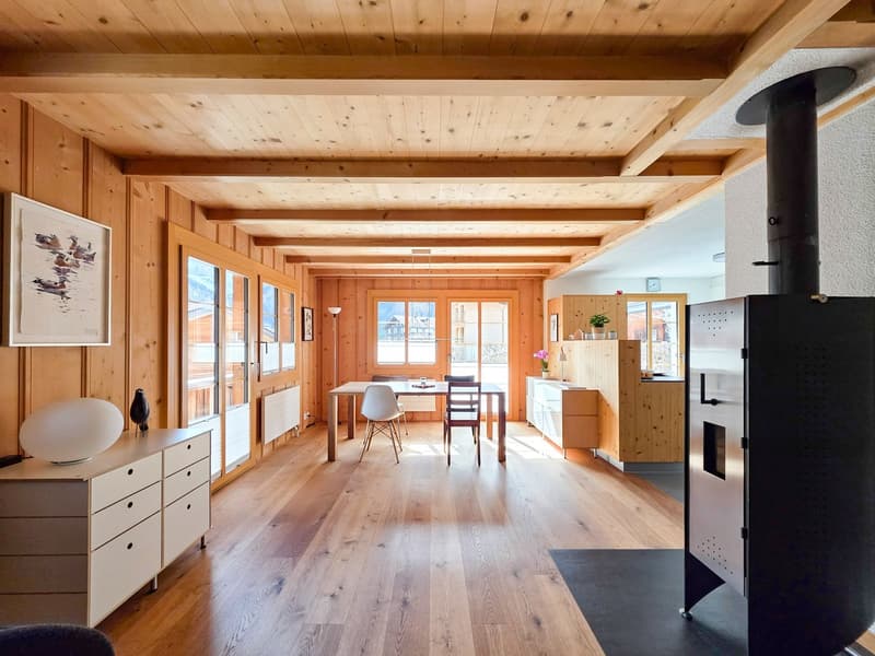 wooden walls, wooden floor, dining table, chairs, fireplace, white cabinets, picture frames, lamps
