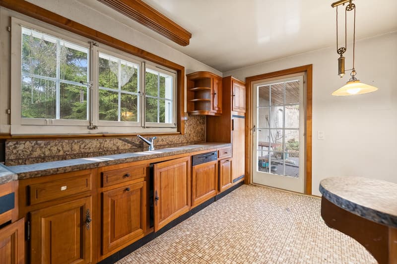 marble countertop, wooden cabinets, large windows, white flooring, dishwasher