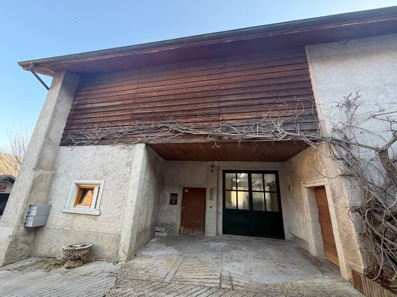 stone house with wooden roof, brick wall, two wooden doors, open garage